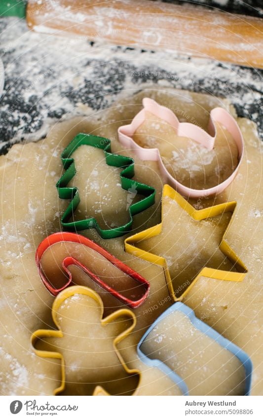 Bunte Weihnachtsplätzchenausstecher auf ausgerolltem Teig angeordnet backen Backblech schwarz Zuckerstange Feier Kindheit Kinder Weihnachten Weihnachtsbaum