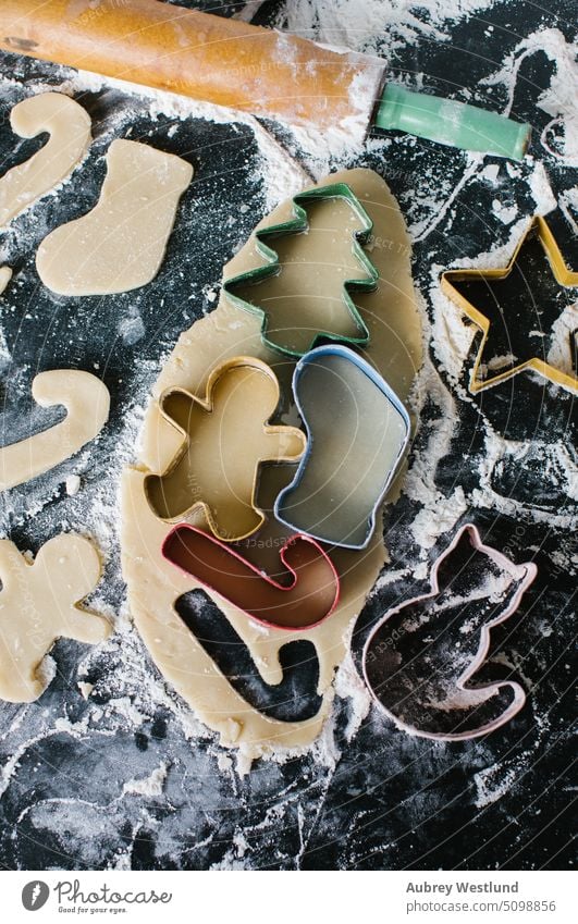 Bunte Weihnachtsplätzchenausstecher auf ausgerolltem Teig angeordnet backen Backblech schwarz Zuckerstange Feier Kindheit Kinder Weihnachten Weihnachtsbaum