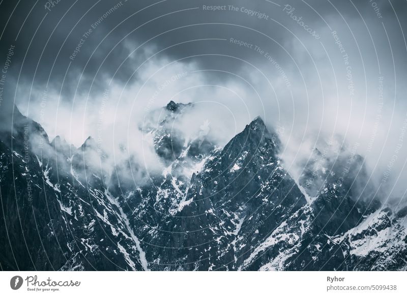 Wolken fliegen tief über Felsen. Mountains Peaks mit Schnee bedeckt. Abwechslungsreiche Berglandschaft in der Region Mtskheta-Mtianeti, Georgien hoch Winter