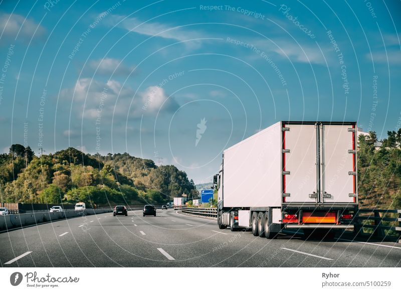 LKW oder Triebfahrzeug in Bewegung auf Straße, Autobahn. Asphalt Autobahn Highway vor dem Hintergrund der Waldlandschaft. Business Transport und Trucking Industrie