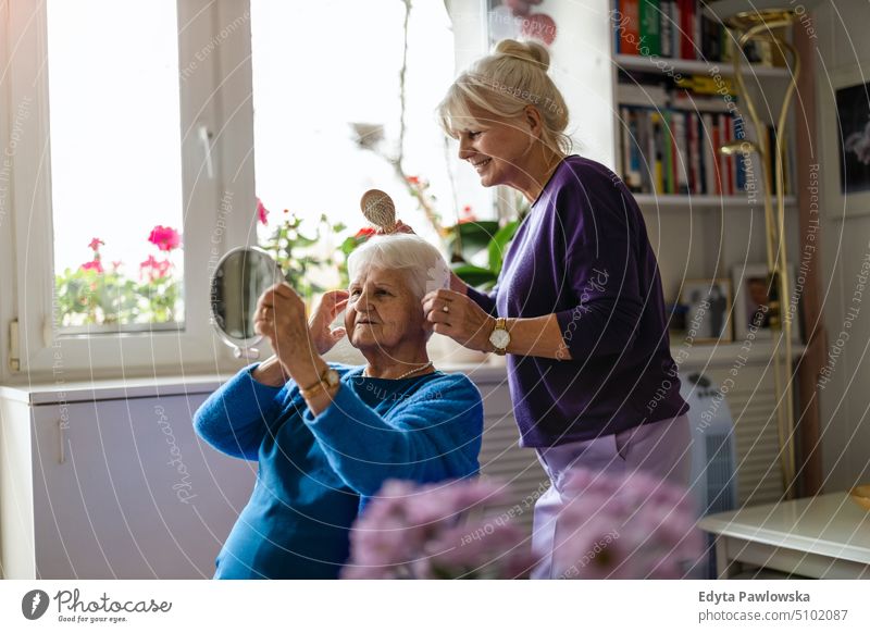 Frau kämmt die Haare ihrer älteren Mutter Lächeln Glück genießend positiv Freude Menschen Senior reif heimwärts Haus alt Alterung häusliches Leben Großmutter