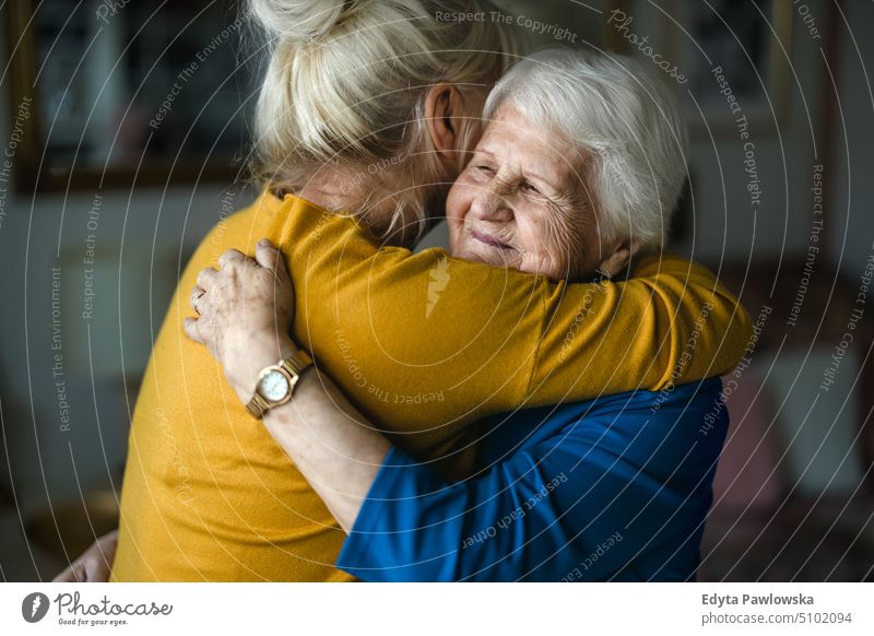 Frau, die ihre ältere Mutter umarmt Lächeln Glück genießend positiv Freude Menschen Senior reif heimwärts Haus alt Alterung häusliches Leben Großmutter