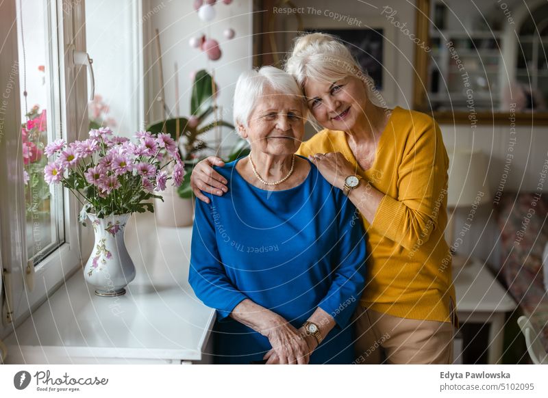 Frau, die ihre ältere Mutter umarmt Lächeln Glück genießend positiv Freude Menschen Senior reif heimwärts Haus alt Alterung häusliches Leben Großmutter