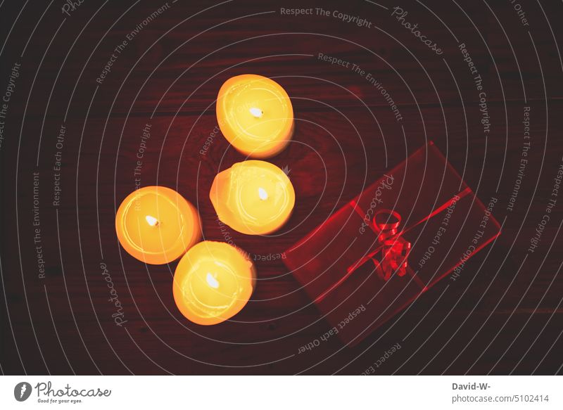 Weihnachten - brennende Kerzen und ein Weihnachtsgeschenk Geschenk leuchten festlich Kerzenschein weihnachtlich Heiligabend rot Licht Weihnachtsstimmung