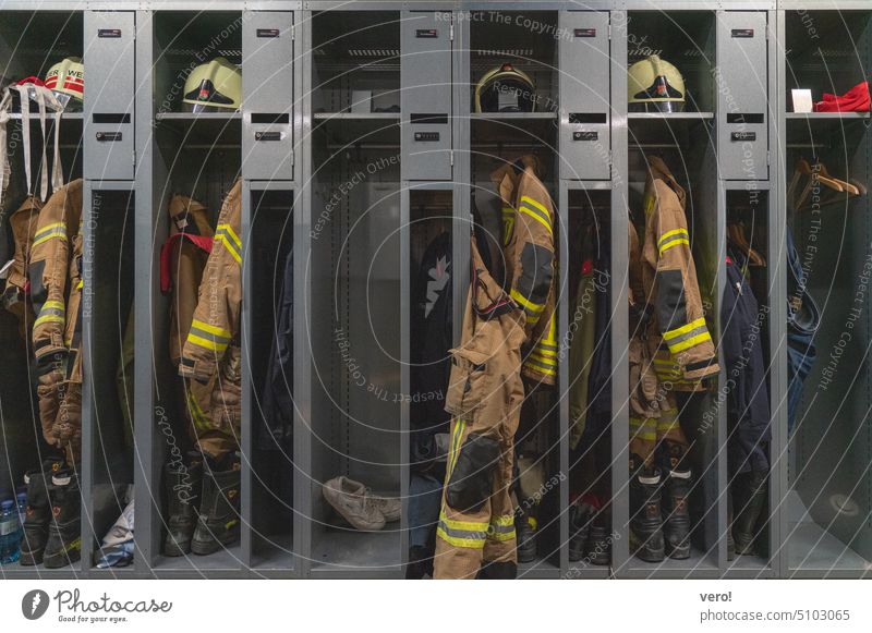 Feuerwehr Einsatzbekleidung in offenen Kästen Innenaufnahme Farbfoto Feuerwehrjacke gelb Mantel Jacke Schutzbekleidung Arbeitsbekleidung Bekleidung Beruf