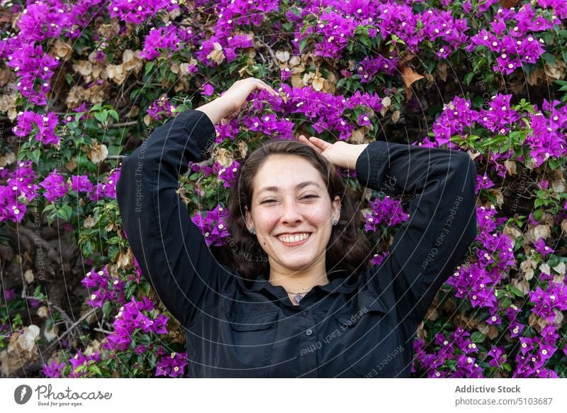 Lächelnde Frau im blühenden Garten Blütezeit Park Landschaft genießen Blume heiter Vorschein Kälte idyllisch ruhen positiv Stil Dame Blatt charmant Strauch