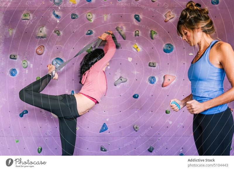 Bergsteigerinnen beim Aufwärmen in der Turnhalle Sportlerinnen vorbereiten Training Aufsteiger Wand Fitnessstudio Widerstandsband Griff Trainerin Frau