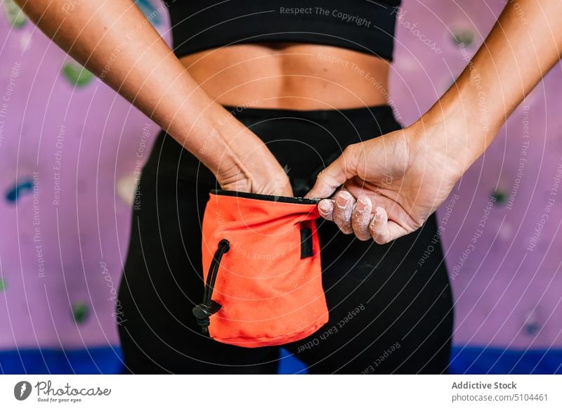 Crop-Kletterin nimmt Kreide aus dem Beutel Sportlerin vorbereiten Aufsteiger Tasche Fitnessstudio Bouldern Training Sportkleidung Frau Herausforderung Aktivität