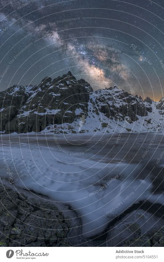 Verschneite Berge über einem See im Winter unter einem sternenklaren Milchstraßenhimmel Schnee Berge u. Gebirge trist Milchstrasse Seeufer gefroren kalt