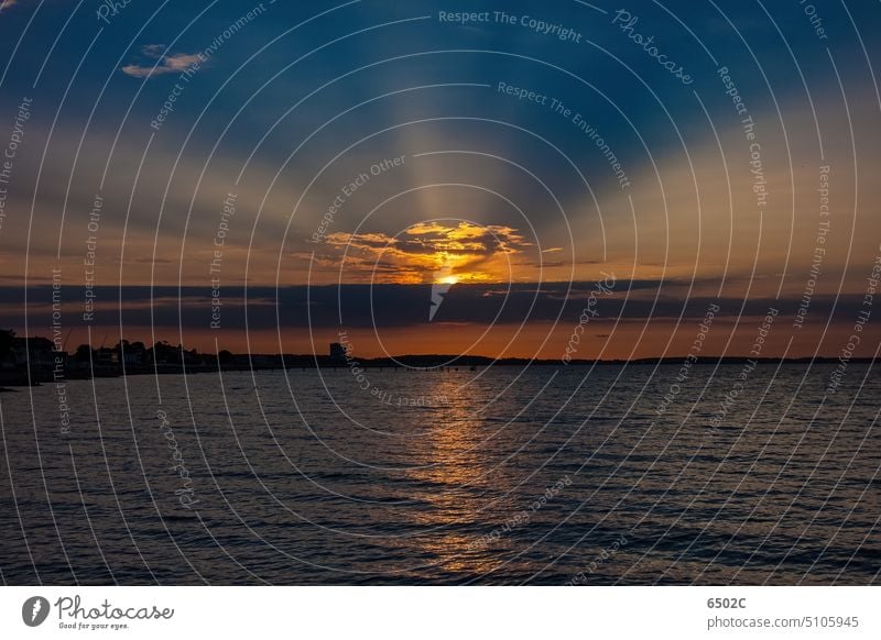 Sonnenuntergang in der Lübecker Bucht Ostsee Strahlen Wolken Kontrast