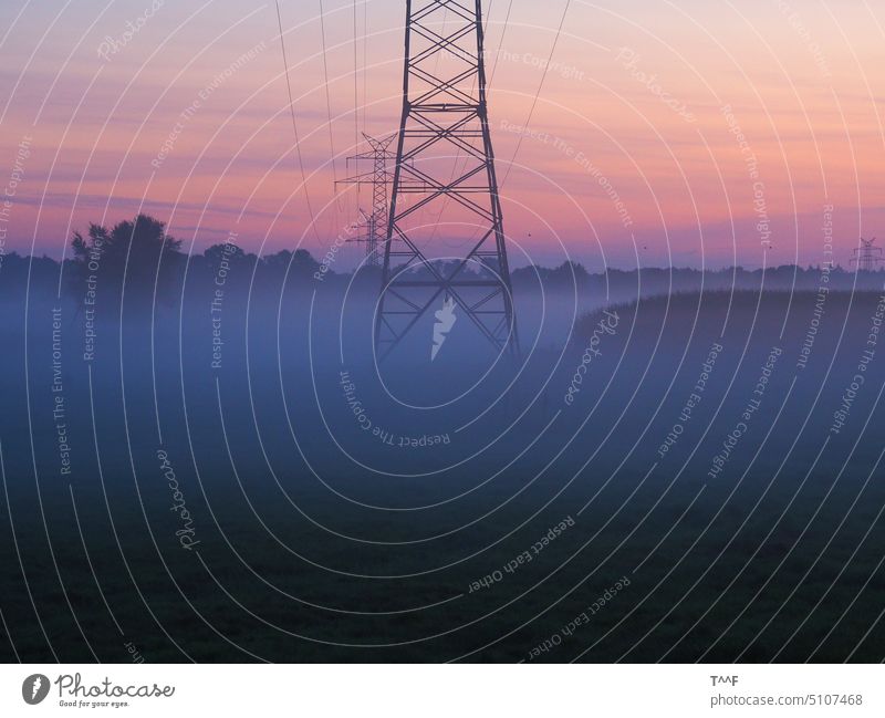 Die Energie erwacht – Hochspannungsfreileitung im Morgennebel bei Sonnenaufgang Strommast Gittermast Mast Energieversorgung Energiewende nebulös ungewiss