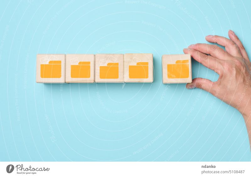 Würfel mit Ordnersymbolen auf blauem Hintergrund. Konzept der Datensystematisierung, papierloser Informationsaustausch Mappe Hand Ikon Management