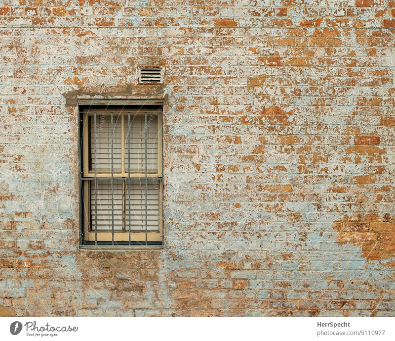 Backsteinfassade mit vergittertem Fenster Backsteinwand Mauer Außenaufnahme Fassade alt Strukturen & Formen rot Menschenleer Muster Detailaufnahme chaotisch