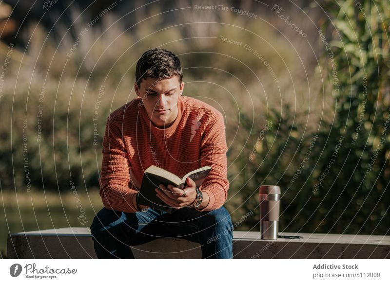 Mann liest Buch im Park Konzentration lesen Natur Hobby Bank Literatur männlich malerisch interessant lässig Roman Baum Fokus Stein Freizeit Gras Buchse Typ