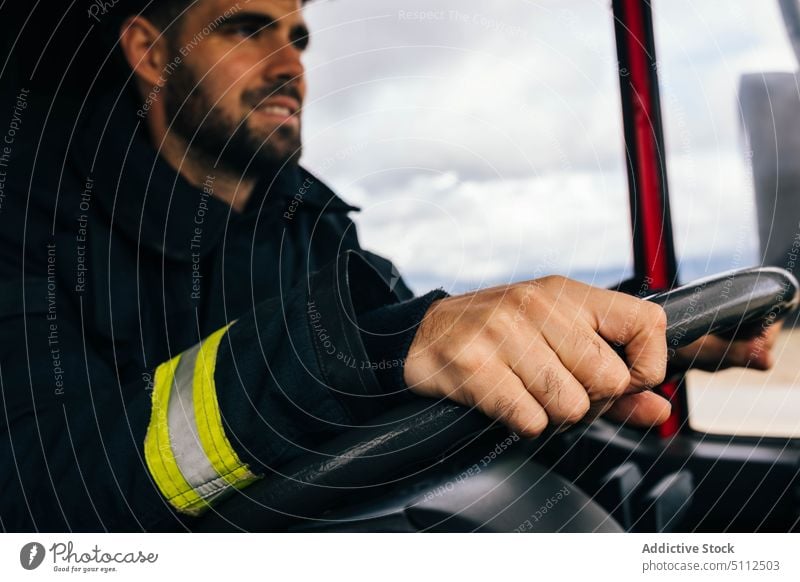 Hispanischer Feuerwehrmann fährt Feuerwehrauto Laufwerk Lächeln Arbeit Notfall freundlich Uniform behüten Porträt männlich Erwachsener hispanisch ethnisch