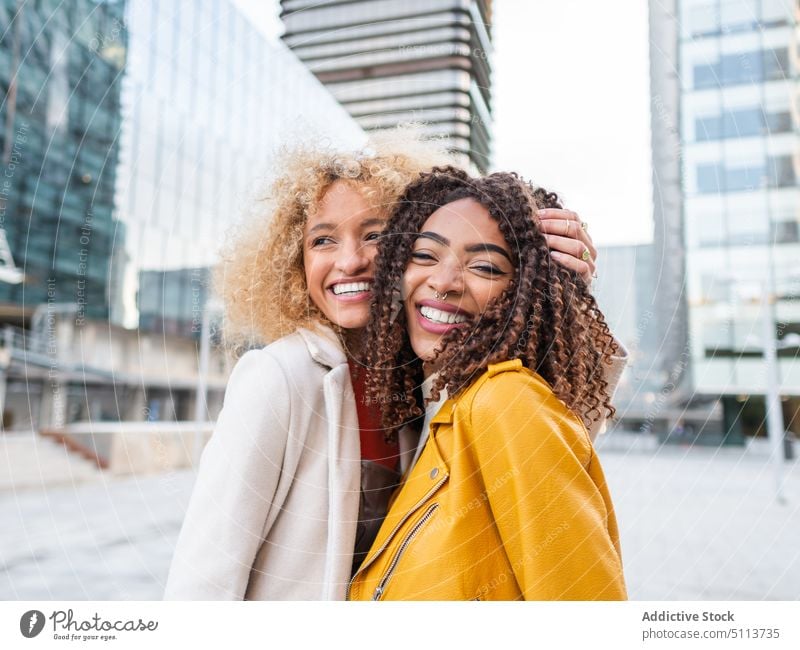 Lächelnde coole diverse Damen stehen auf der Straße Frauen Freund Großstadt Stil heiter Umarmen positiv Porträt Zusammensein Zeit verbringen jung