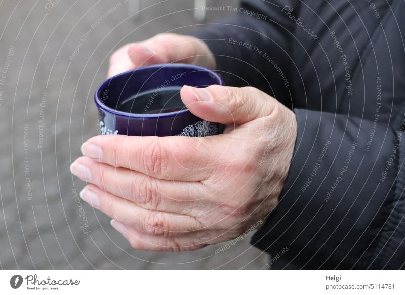 Hände halten eine Tasse mit heißem Punsch Mensch Detailaufnahme Glühwein festhalten wärmen Getränk Heißgetränk Weihnachtsmarkt Winter Dezember