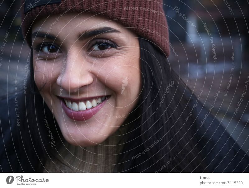 lächelnde Frau mit Mütze frau feminin lachen lächeön mütze pullover winter dunkelhaarig langhaarig Gute Laune gutgelaunt Blick in die Kamera Fröhlichkeit