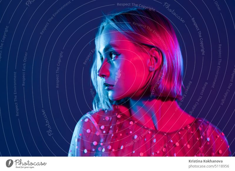 Mysteriöser Hipster-Teenager. Porträt von Millennial hübsches Mädchen mit kurzer Frisur mit Neonlicht. Gefärbte blaue und rosa Haare. Licht Glamour Mode Frau