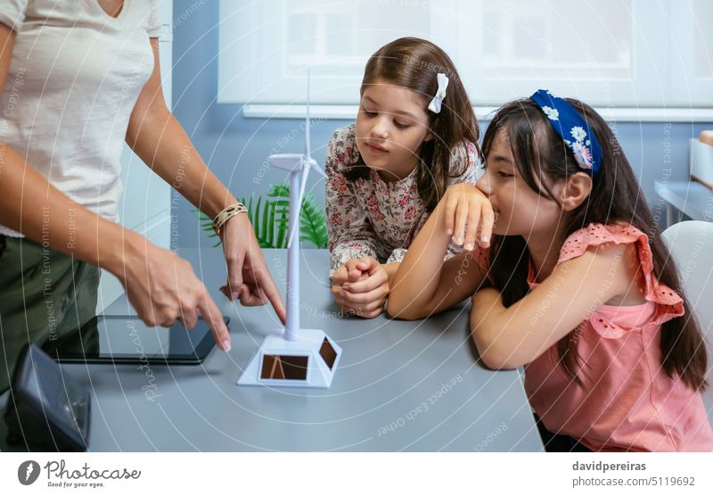 Schüler betrachten ein Solarwindrad, während der Lehrer im Ökologieunterricht etwas erklärt Frau Mädchen Schulmädchen Kinder Blick Windmühle solar regenerativ