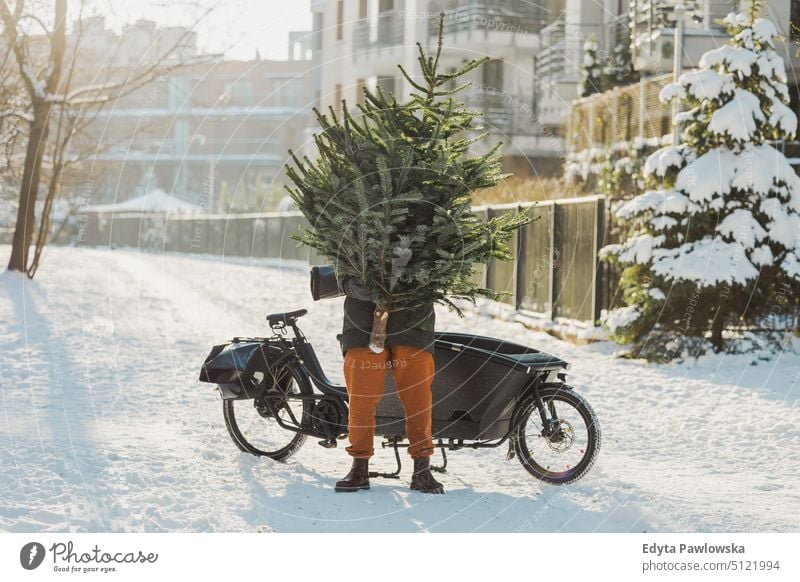 Mann transportiert Weihnachtsbaum auf Lastenfahrrad nachhaltiger Transport transportierend ökologisch Ökologie Kohlenstoff-Fußabdruck umweltfreundlich Lastenrad