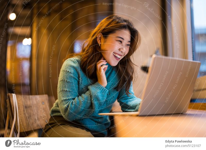 Junge Frau arbeitet an einem Laptop in einem Café echte Menschen offen Mädchen jung Erwachsener Spaß Jahrtausende Jahrtausendgeneration asiatisch Japanisch