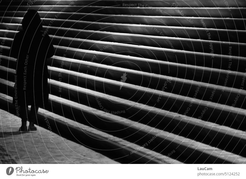 Am Ende der Treppe steht eine dunkle Gestalt Person düster Schatten Stufen aufwärts abwärts unheimlich geheimnisvoll einsam alleine Licht Licht und Schatten