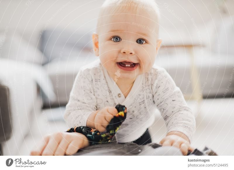 Niedliches Baby spielt, krabbelt und steht zu Hause auf. Baby spielt zu Hause Junge neugeboren Säugling spielen Kindheit Entwicklung Spielzeug Entertainment