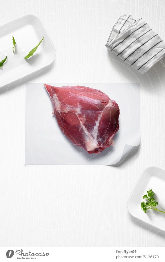 Ganzes Rindersteak auf einer Küche mit einigen Kräutern Rindfleisch Steak Spielfigur ganz Fleisch roh Metzger Werkstatt Textfreiraum Petersilie Rucola Koch