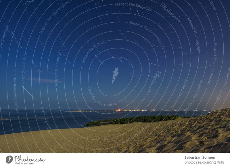 Langzeitbelichtung des Startrails bei Nacht über der riesigen natürlichen Sandformation Dune du Pilat im Mondlicht, Arcachon, Nouvelle-Aquitaine, Frankreich