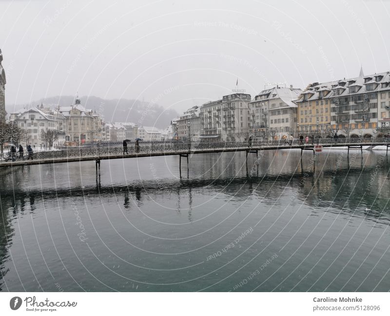 Blick auf die frisch verschneite Luzerner Rathausbrücke mit Fussgängern Brücke Schnee Winter Außenaufnahme kalt Frost Himmel Landschaft Tag Rathausbrücke Luzern