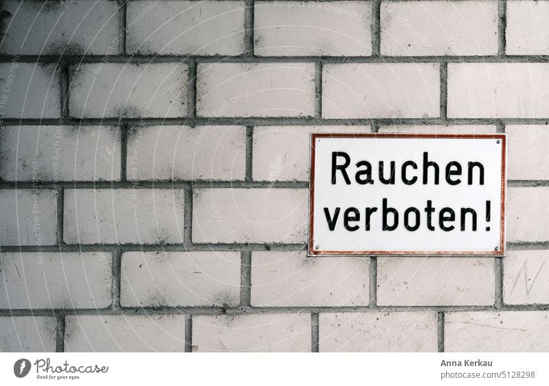 Ein "Rauchen verboten" Schild auf schmutzig grau-weissen Klinkern Verbote Warnschild Verbotsschild Nichtraucherzone Nichtraucherschutz Rauchverbot