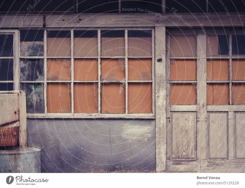 Alte Werkstattfassade Tür Eingang Holz alt orange grau verwittert wand Gebäude Fassade Außenaufnahme trist Farbfoto Gedeckte Farben Eingangstür Fenster Wand