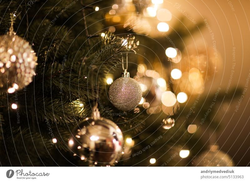 Nahaufnahme von schönen Tannenzweigen mit glänzenden goldenen Kugel oder Ball, Weihnachtsschmuck und Lichter, Weihnachtsferien Hintergrund. copy space. Dekoration auf Weihnachtsbaum. Festliche neue 2023 Jahr