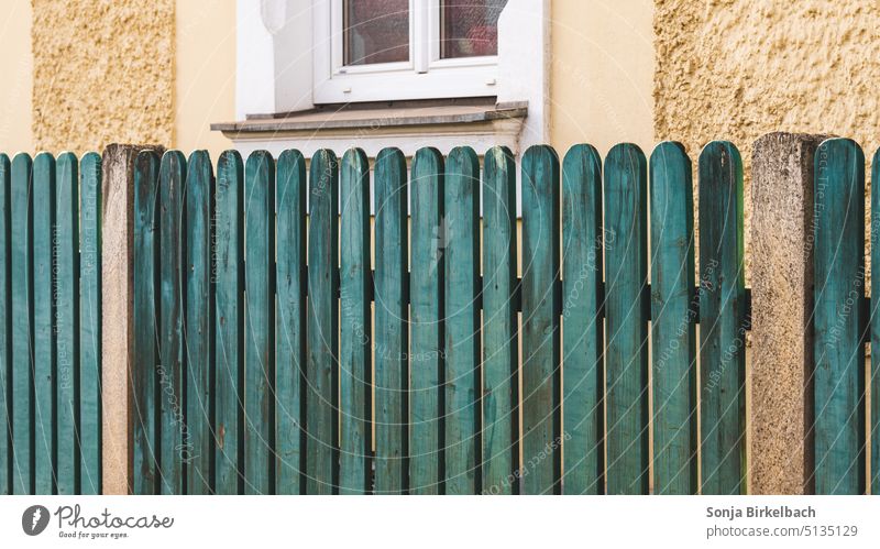 Ein grüner Zaun in all dem Grau (Gelb) Umsäunung Gartenzaun Lattenzaun Haus Grundstück alt Außenaufnahme Grenze Holzzaun Menschenleer Farbfoto lattenzaun