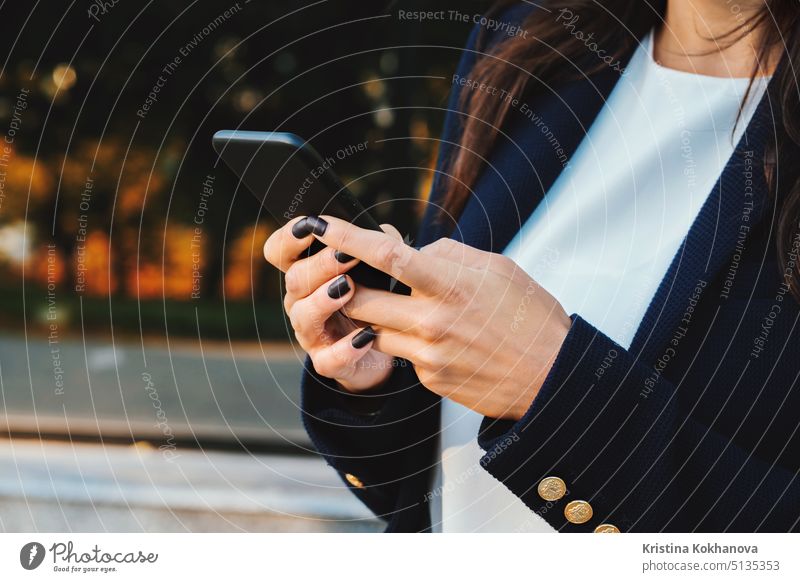 Geschäftsfrau mit Smartphone. Studentin mit Mobiltelefon. Schöne Frau mit Brille surft im Internet auf einem mobilen Gerät. Frau mit modernem technologischen Gerät.