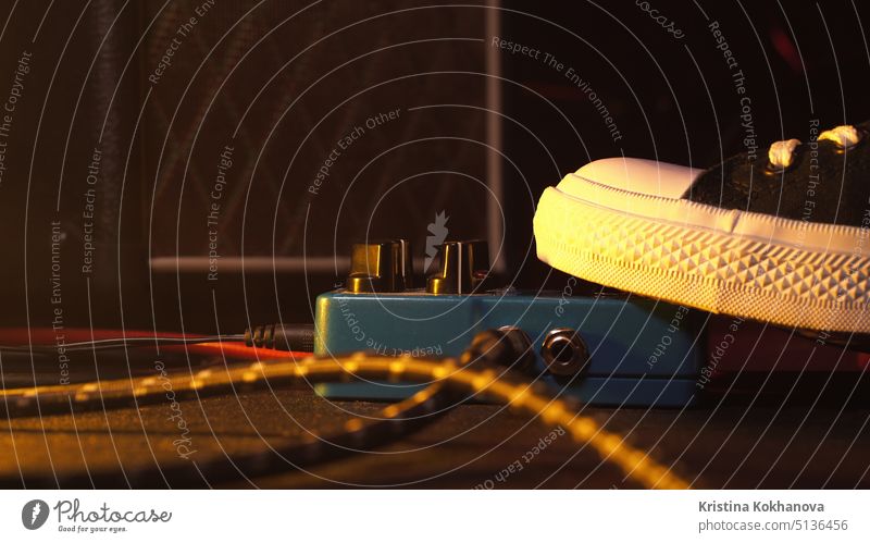 Gitarrenpedale und Fußschalter im Aufnahmeraum. Nahaufnahme von Gitarrenpedalen und dem Fuß des Musikers, der darauf klopft, um verschiedene Sounds zu erzeugen. Makroaufnahme