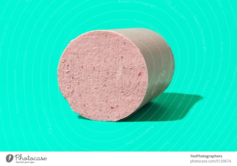 Hausgemachte Wurst isoliert auf grünem Hintergrund. Amuse-Gueule Fleischwurst gekocht Bologna Frühstück hell Hähnchen Chunk Nahaufnahme kalt Farbe Textfreiraum