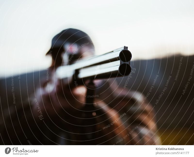 Nahaufnahme eines doppelläufigen Jagdgewehrs. Jäger Mann trägt warmen Mantel Ziele der Feind auf dem Schlachtfeld mit Gewehr. Unbekannter Mann jagt in den Wäldern. Fokus auf den Lauf