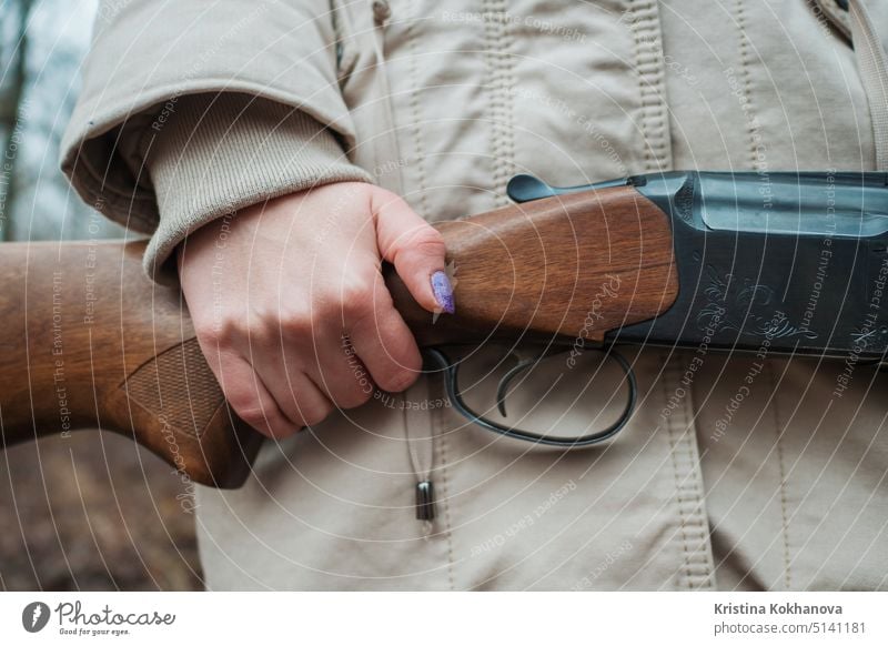 Jägerin in warmer Kleidung mit Gewehr. Mädchen auf der Jagd im Wald hält ihr Gewehr in Großaufnahme. Aktivität Erwachsener zielen Ziel Adel Herbst Hintergrund