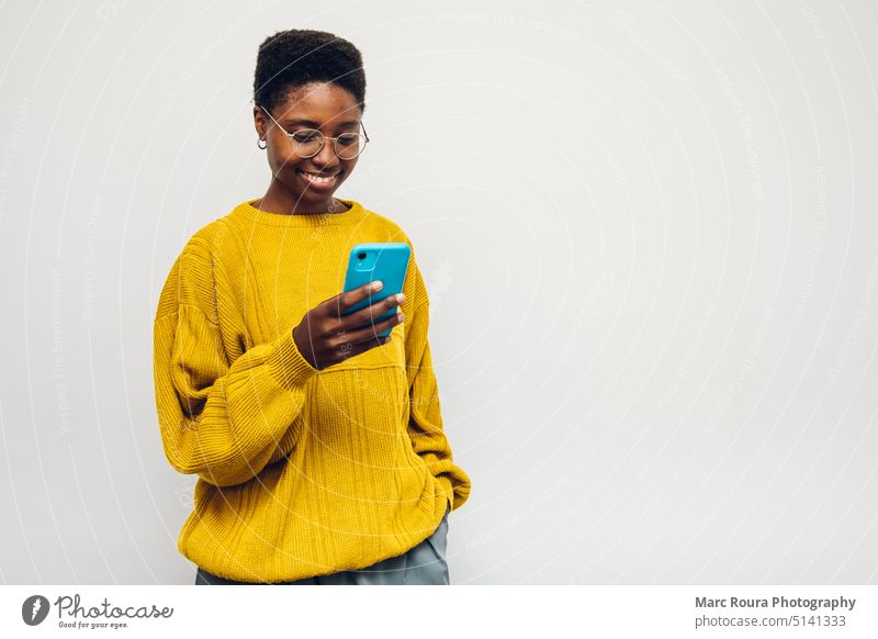 Frau textet auf Handy Erwachsener Afrikanisch Audio blanko Zelle Funktelefon plaudernd Mitteilung Kontakt Gerät digital Kopfhörer leer Mädchen Mädchen gehend