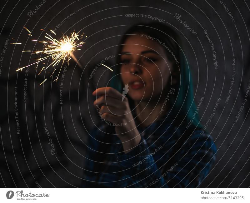 Porträt von Modell Mädchen mit blauen Haaren sieht mit Wunderkerzen in ihren Händen. Nahaufnahme. Schöne junge Teenager in der Stadt Tunnel mit Spaß mit bengalischen Feuer.