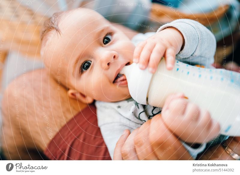 Kleiner Babyjunge trinkt Muttermilch aus der Flasche und lächelt Junge Pflege Kaukasier Kind Kindheit niedlich Lebensmittel Säugling wenig melken bezaubernd