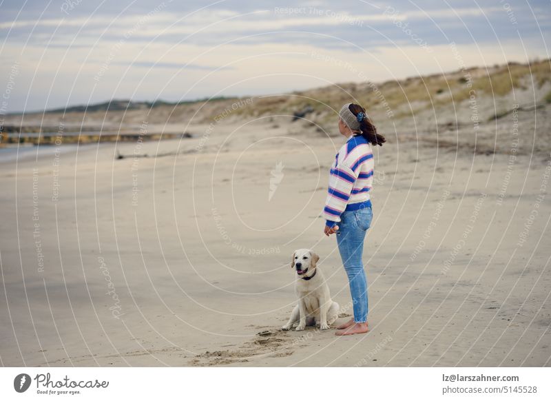 Brünette Frau mittleren Alters am leeren Strand mit ihrem Labrador-Retriever-Hund Winter Profil Textfreiraum Herbst überrascht nass feucht Küste Ufer