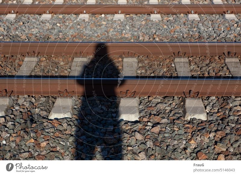 voll dämlich |mit dem Kopf auf den Schienen... Gleise Schienennetz Eisenbahn Schienenverkehr Verkehrswege Bahn Schwellen Schotter Gleisbett Schatten Mensch