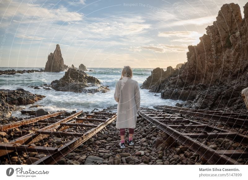 Frau mit Blick auf das Meer in Cabo de Gata in Spanien. Almeria Andalusien Andalusia Hintergrund Strand schön blau Boot Gebäude Kap Küste Küstenlinie Tag Europa