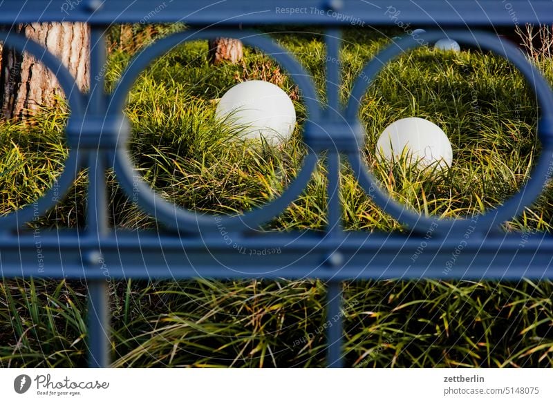 Zwei Kugellampen hinter einem Zaun berlin dahlem erholung erholungsgebiet grün park spaziergang stamm umland zaun metallzaun eisen schmiedeeisern kugel licht