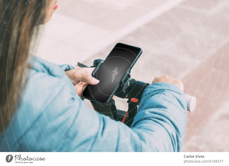 schöne Latina mit langen Haaren, nutzt Smartphone-Anwendung, um Elektroroller zu entsperren aktiv lässig Großstadt abschließen Tag E-Roller Öko elektrisch