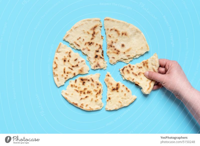 Indisches Fladenbrot von oben gesehen. Frau nimmt ein Stück Naan-Brot Afghane arabisch asiatisch Hintergrund gebacken Bäckerei Balkan blau klassisch Farbe Küche