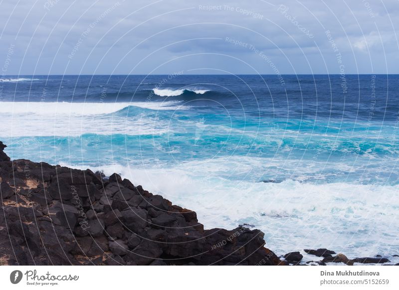 Landschaft mit Blick auf den Ozean mit starken Wellen. Blaue Farbpalette. Surfing Spot mit großen Wellen. Wetterbedingungen und Klimawandel. Urlaub am Strand horizontale Kulisse.